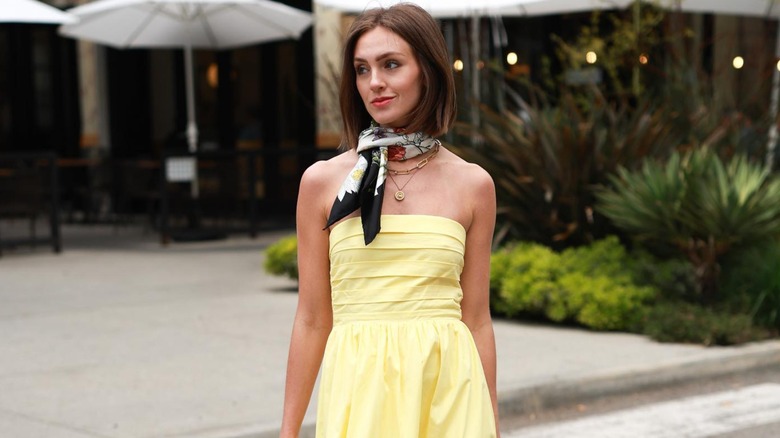 Woman in yellow strapless dress and neck scarf