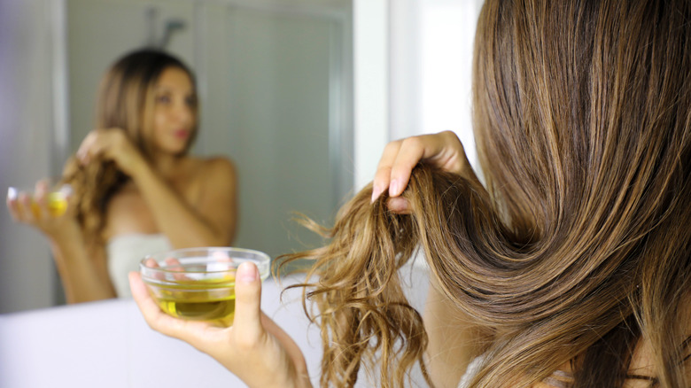 woman applying almond oil to her hair