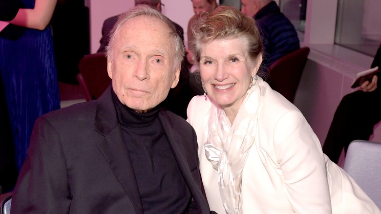 Dick Cavett wearing a black formal wear and Martha Rogers wearing white formal wear