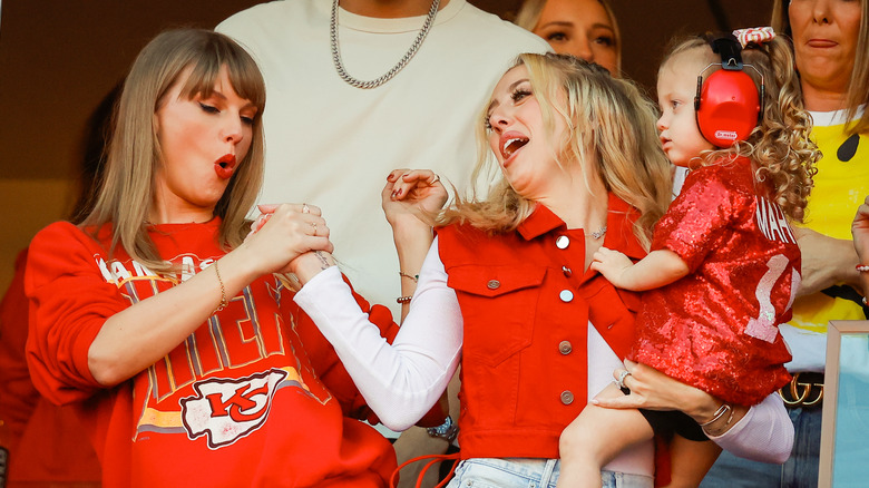 Taylor Swift and Brittany Mahomes hold hands in the stands