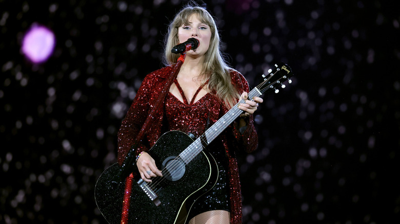 Taylor Swift playing guitar on stage