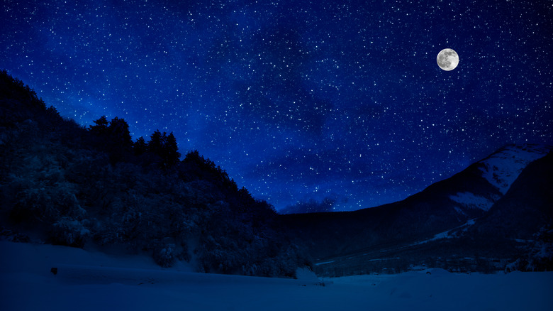 Moon shining above mountains