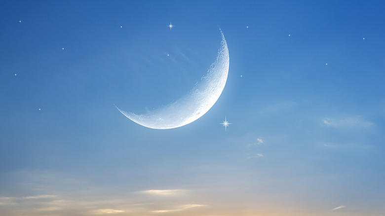 Moon in bright starry sky with clouds 