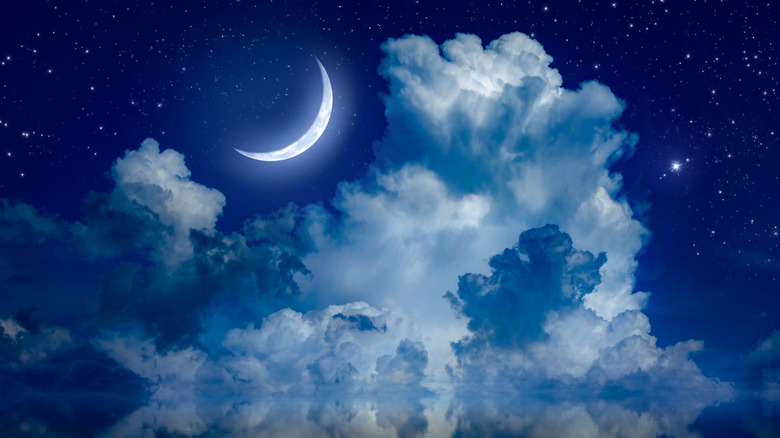 A crescent moon and clouds in the sky 