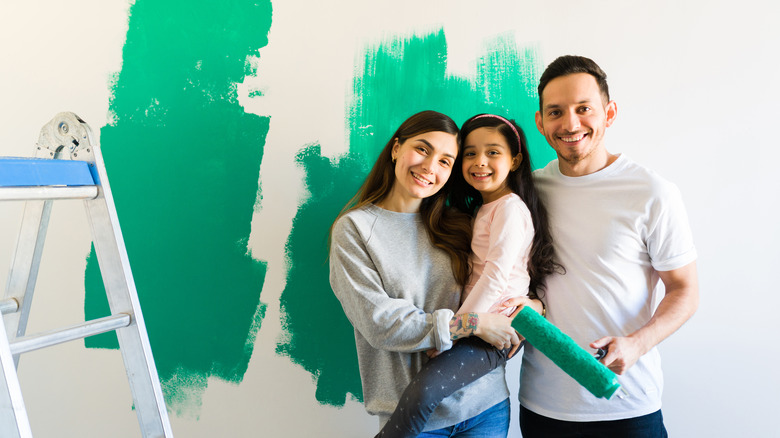 A family paints a wall in their home. 
