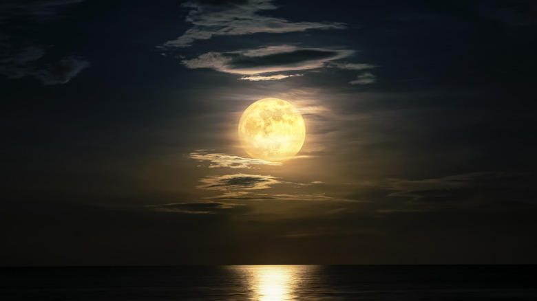 Full moon glowing above ocean 