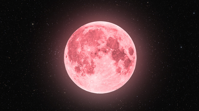 Bright pink full moon in starry sky 