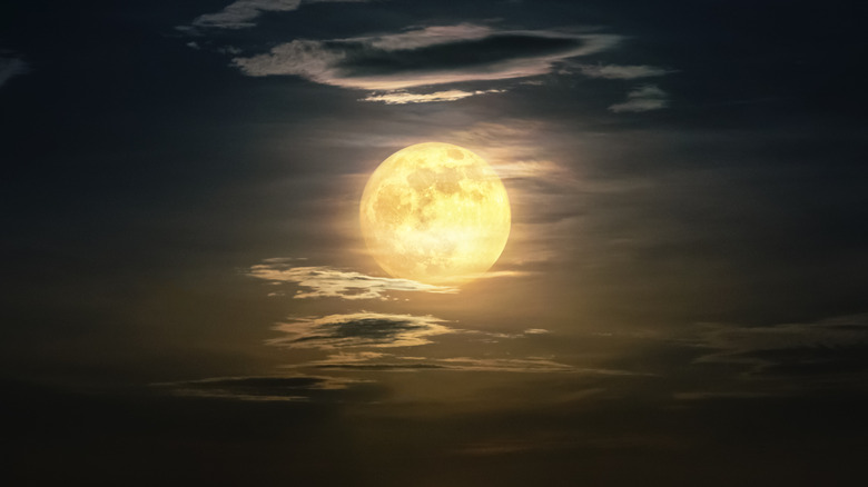 full moon with stars and wispy clouds