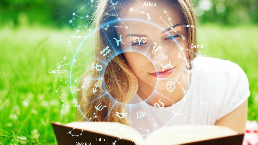Woman reading a book about the zodiac