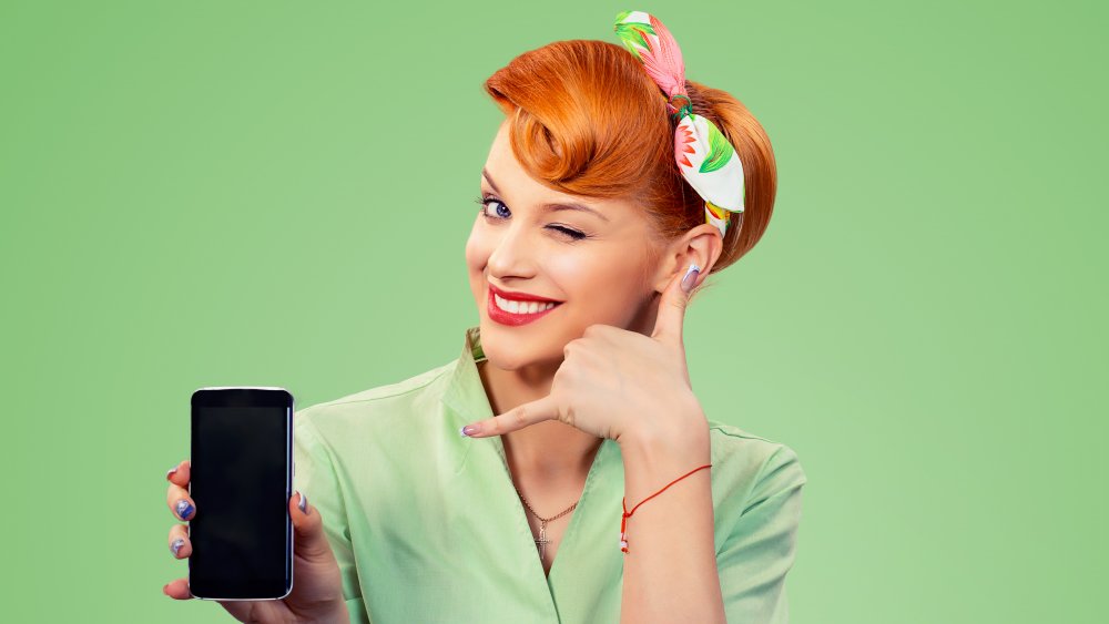 Woman making retro phone hand gesture