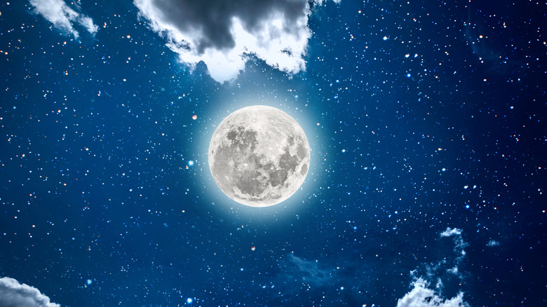 Full moon in a starry sky with clouds 