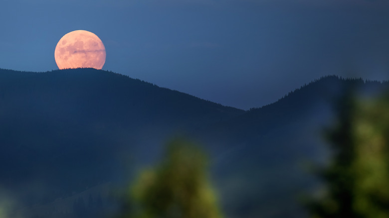 A full moon over a mountain. 