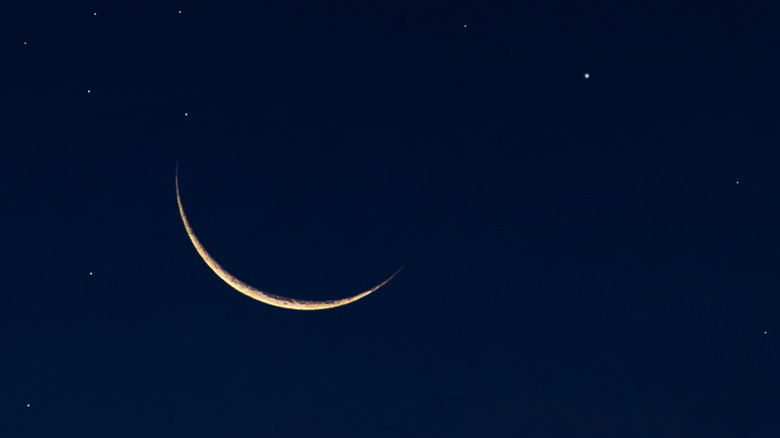 Close-up of new moon crescent showing in a starry sky 
