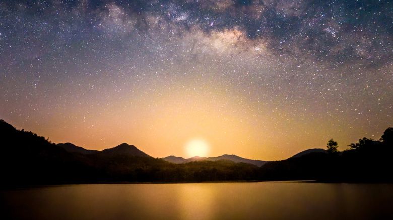 Sunset over mountains and starry sky 