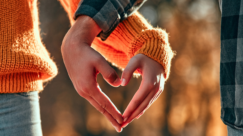 Couple holding hands in heart shape 