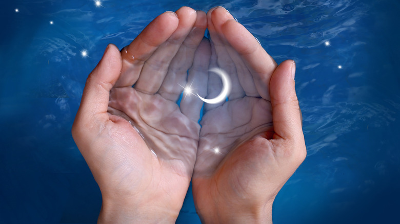 A crescent moon inside someone's hands.