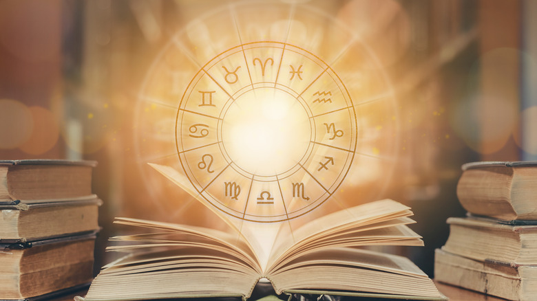 A zodiac wheel above a book 