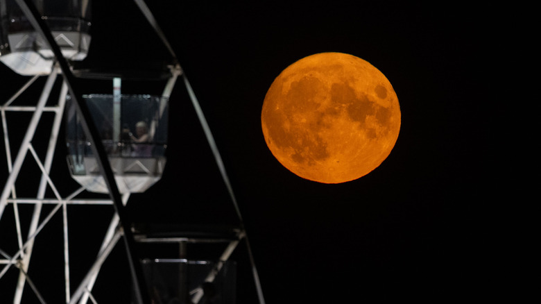 Full moon behind ferris wheel