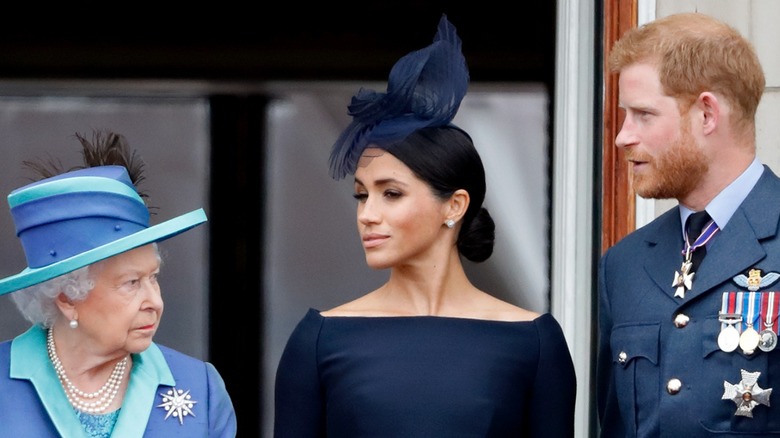 Meghan Markle and Prince Harry look sideways at the queen