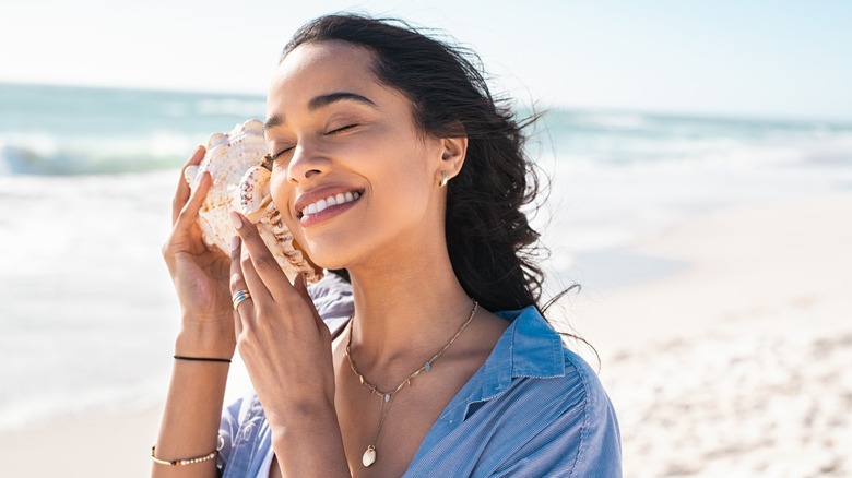 A woman smiling on the beach. 