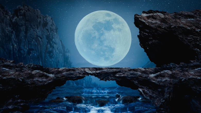 A large full moon over a waterfall. 