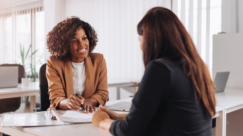 Two women talking in an office. 