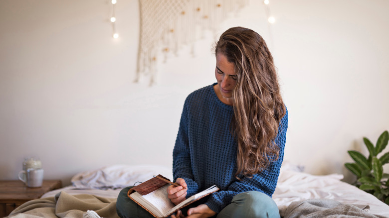 A woman writing in her journal. 