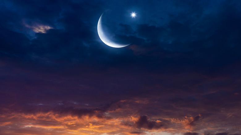Moon and star in cloudy sky