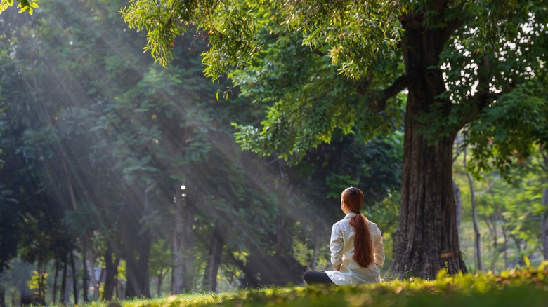 Woman meditating in meadow 