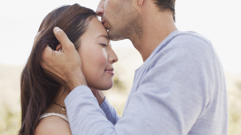 Man kissing girls forehead