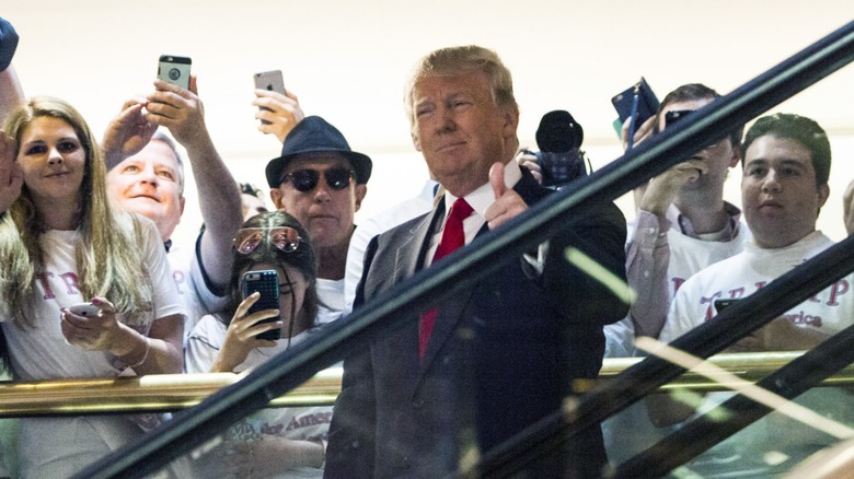 Donald Trump gives a thumbs up on an escalator in Trump Tower (2015)