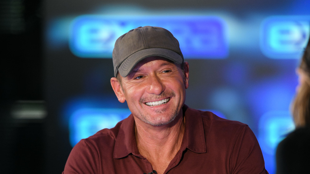 Tim McGraw smiling in baseball cap