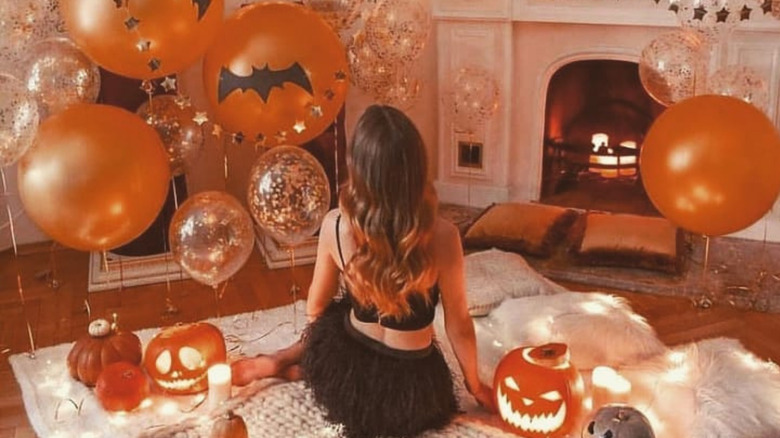 person surrounded by halloween decorations and balloons