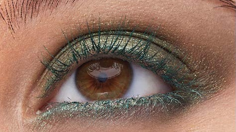 Close-up of brown eye with green mascara and antique gold eyeshadow