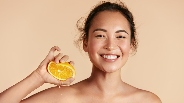 Woman holding orange for skincare