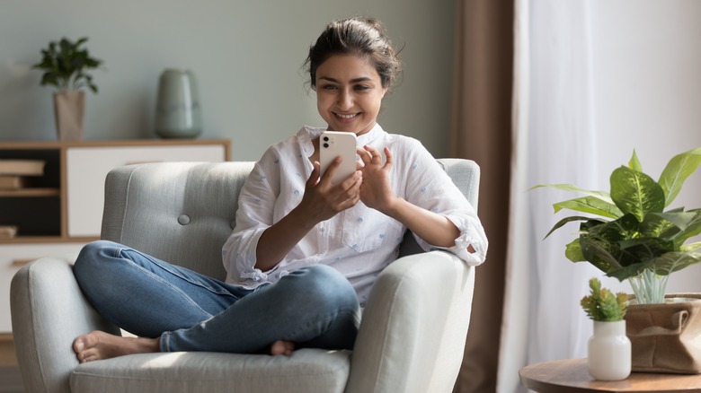 smiling woman using smartphone