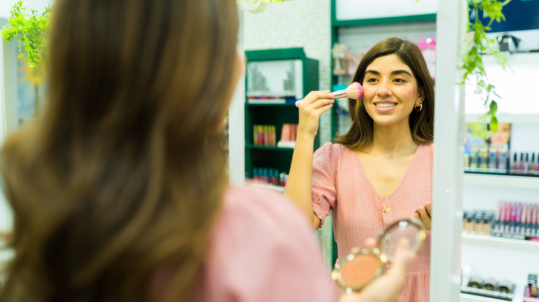 Hispanic woman applying blush