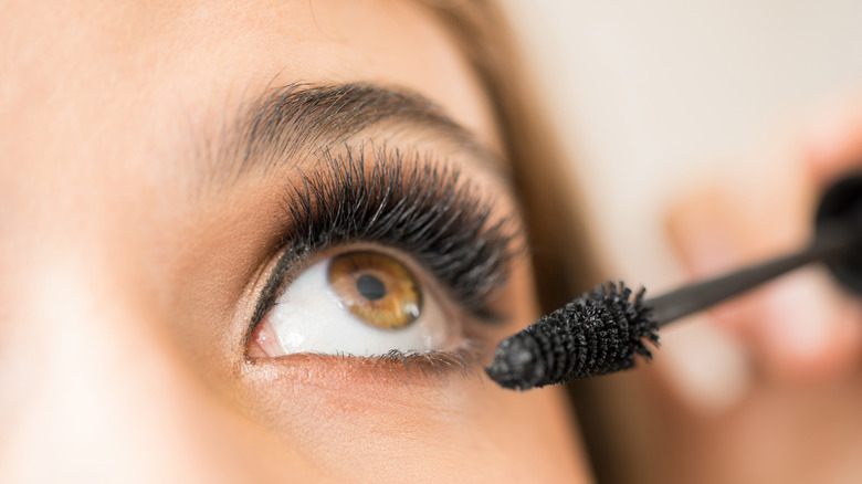 Woman applying mascara to lashes