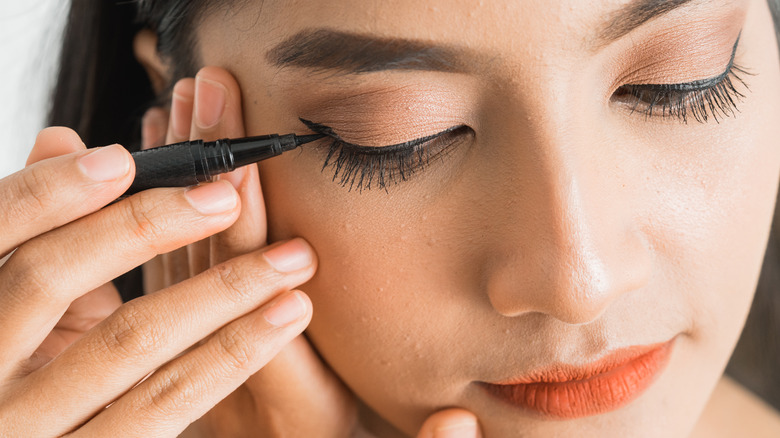 Woman applying eyeliner