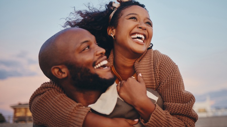 woman on boyfriends back, beach date