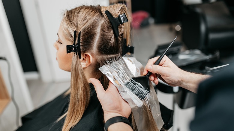 blonde woman getting hair dyed