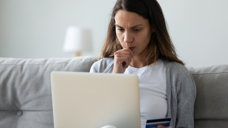 Woman looking at computer, concerned