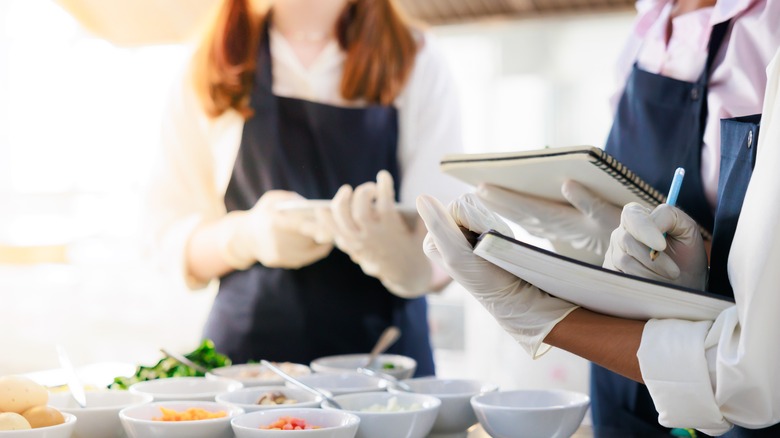 Culinary school student being evaluated by master chefs