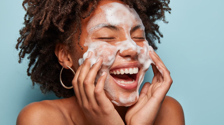 Woman cleansing face