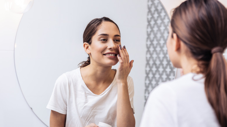 Woman applying face cream 