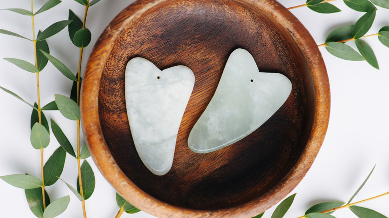 Gua sha tools in wooden bowl