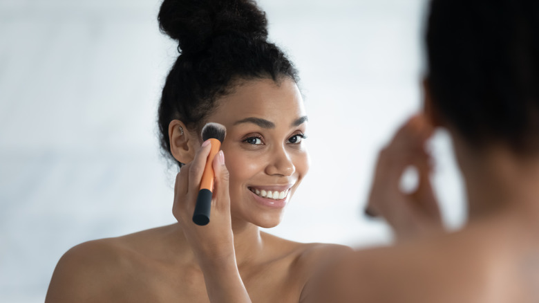 woman applying highlight makeup