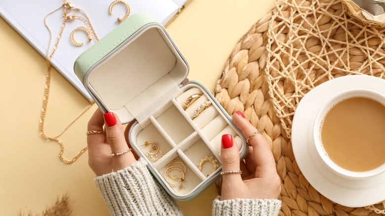 Woman holding jewelry box filled with earrings