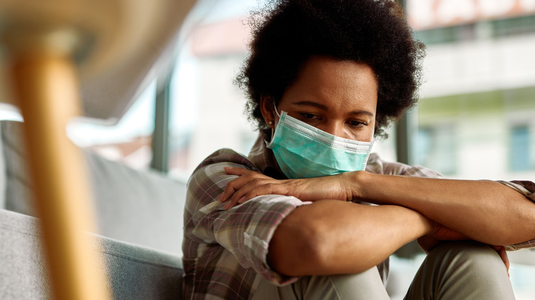 Woman wearing face mask looking upset