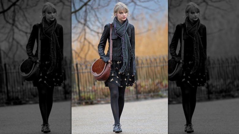 Taylor Swift walking through London in a leather jacket and black dress in 2012